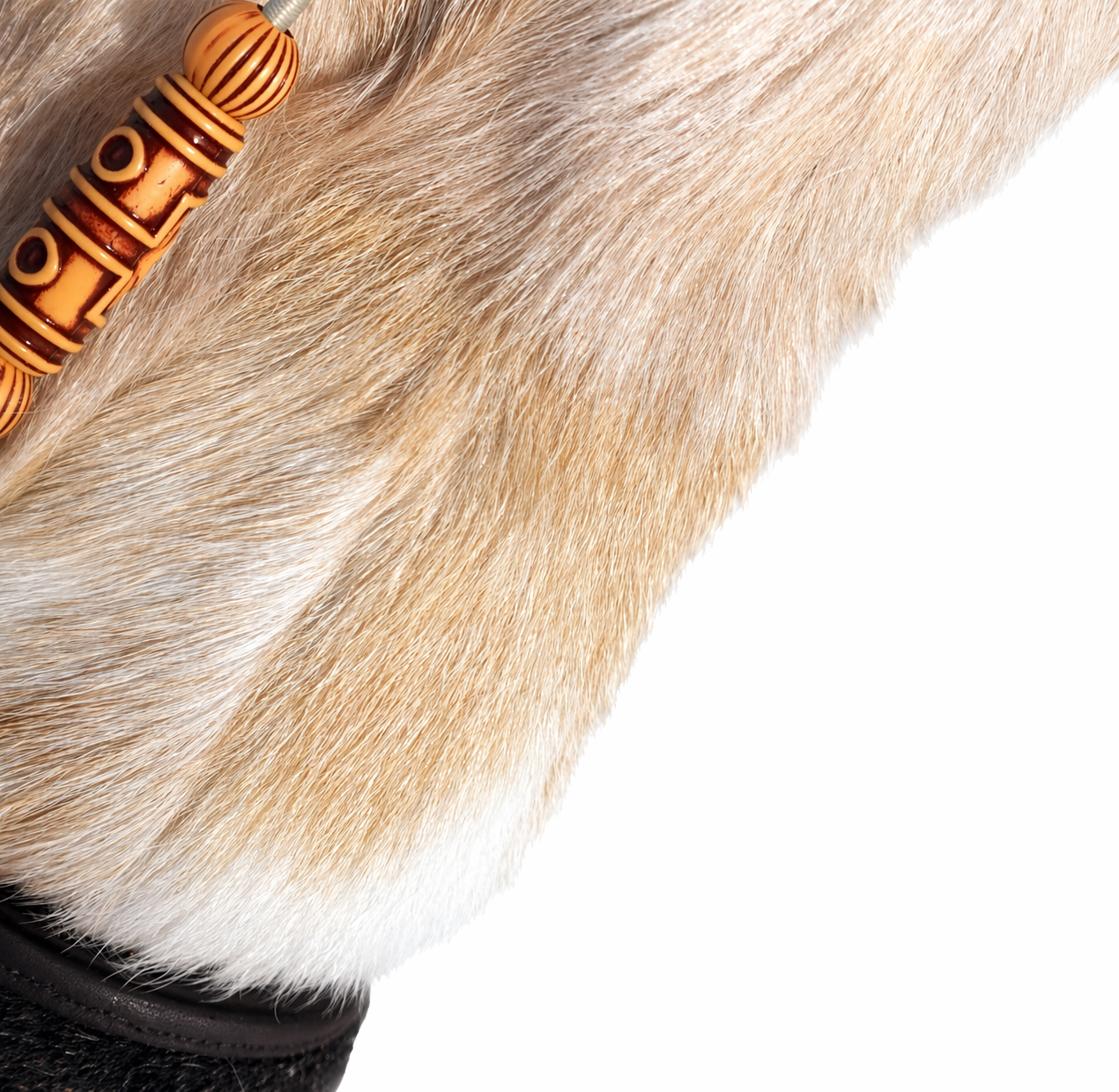 MOGSki boot detail showing natural fur texture with handcrafted decorative bead accent, artisan luxury footwear