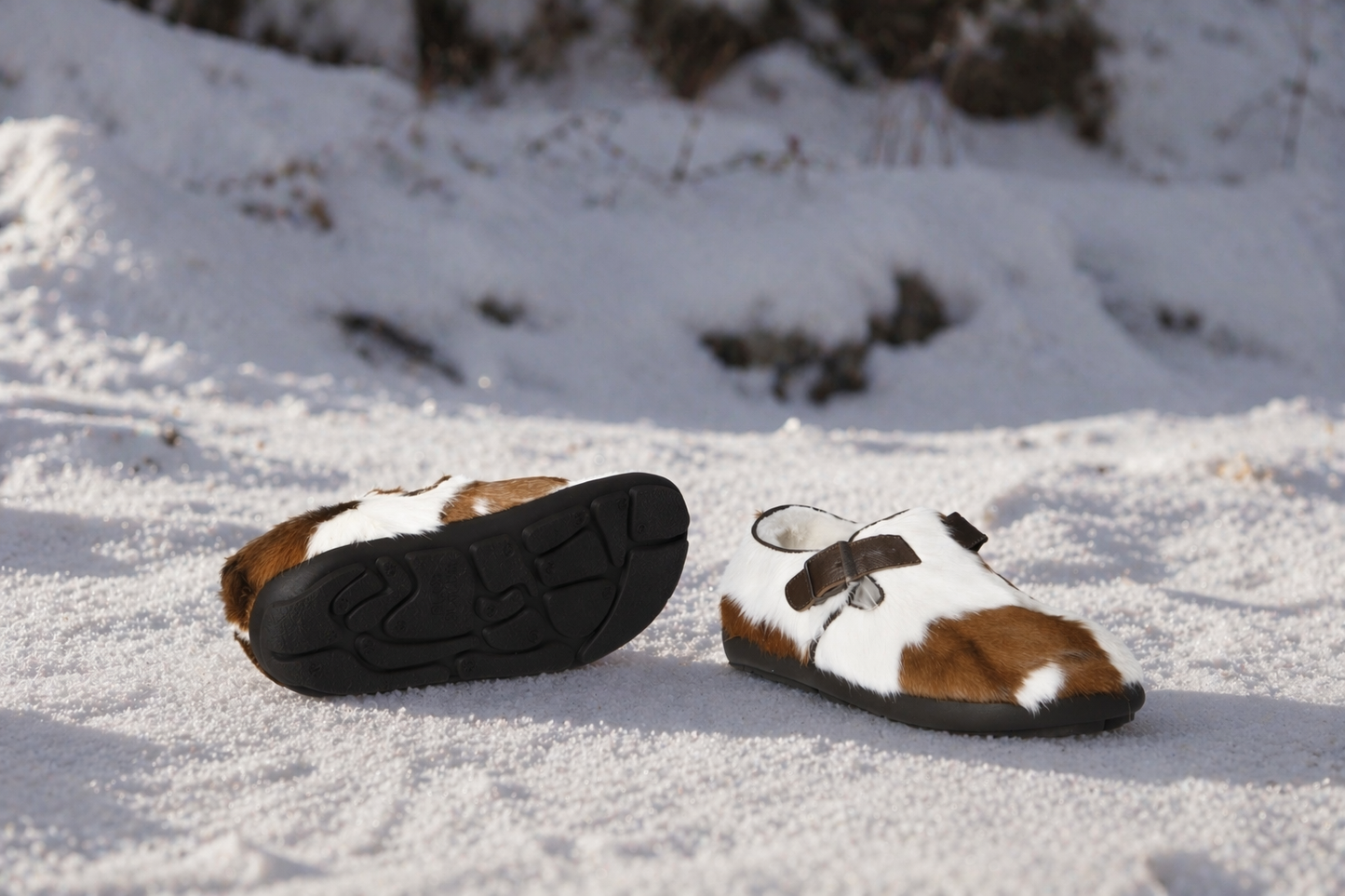 MOGSki natural fur slippers resting in snow, soft winter light, genuine sheepskin luxury footwear handmade Inner Mongolia