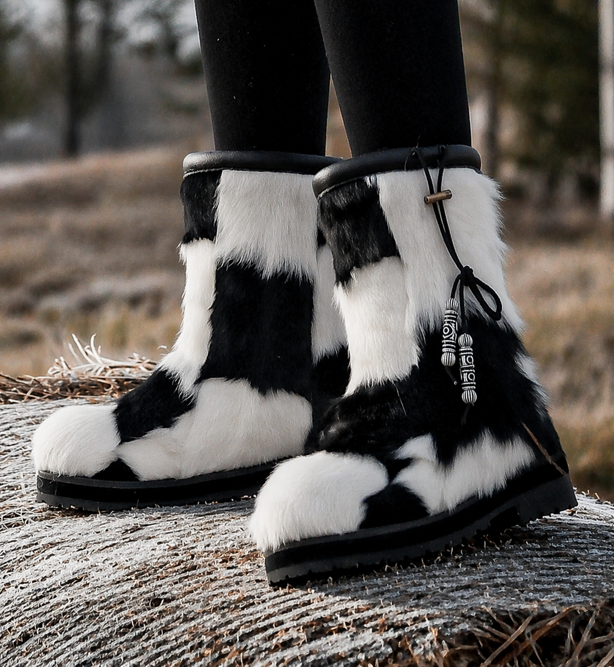 MOGSki natural sheepskin snow boots on frost-covered log in winter forest, handcrafted luxury fur boots Inner Mongolia
