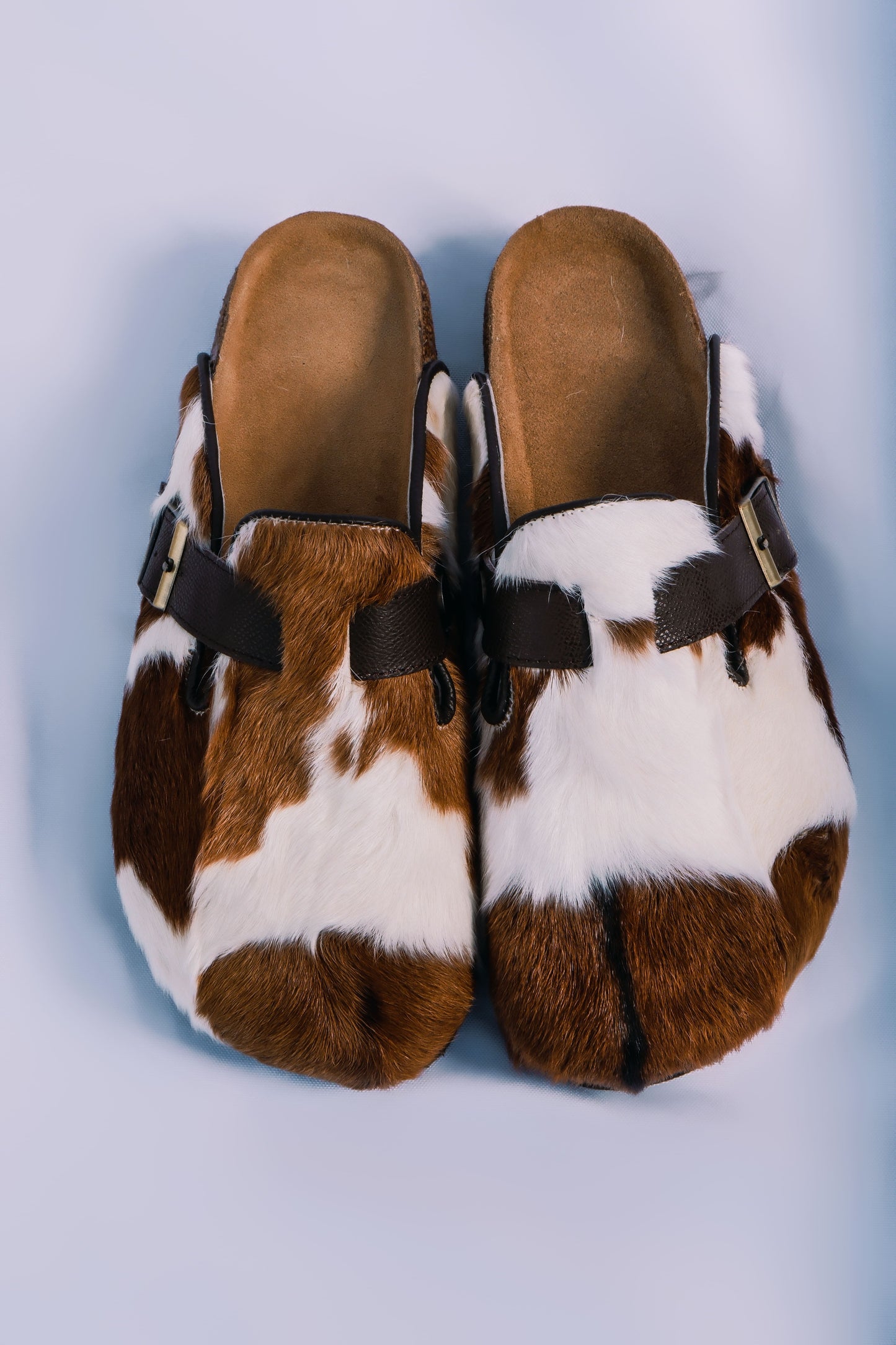 MOGSki natural cowhide fur clogs top view on clean background, luxury handcrafted genuine hide footwear from Inner Mongolia
