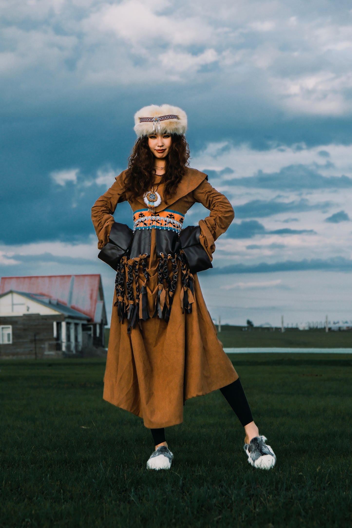 MOGSki handcrafted fur boots worn with golden dress in open landscape, luxury natural hide Mongolian footwear lifestyle shot